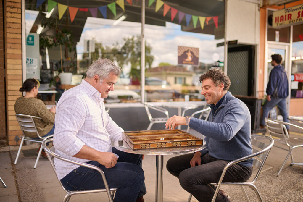 Two Arabic men playing a game at a cafe