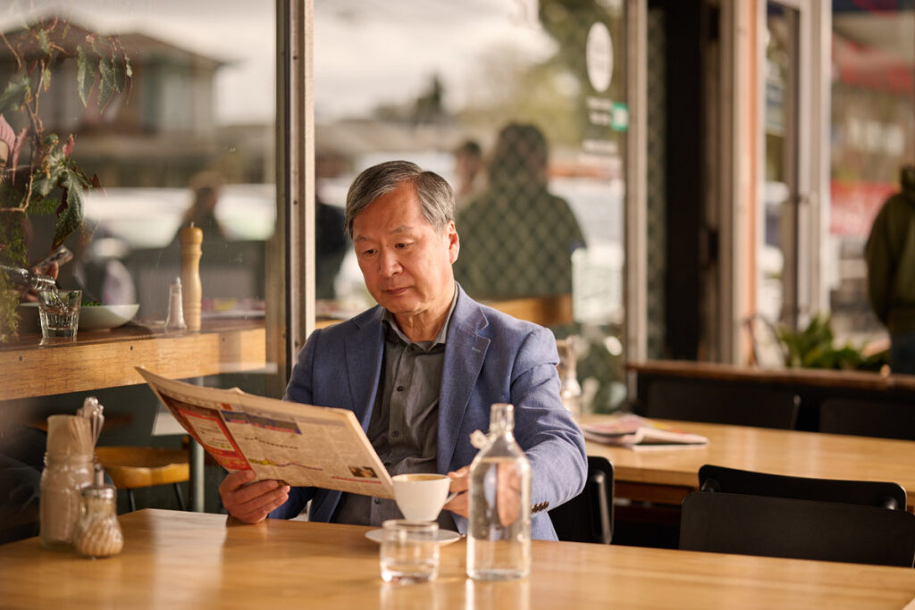 A Chinese man reading the paper at a cafe
