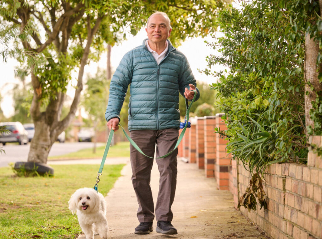 A Vietnamese man walking a dog