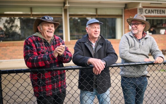Three men at a rural football match