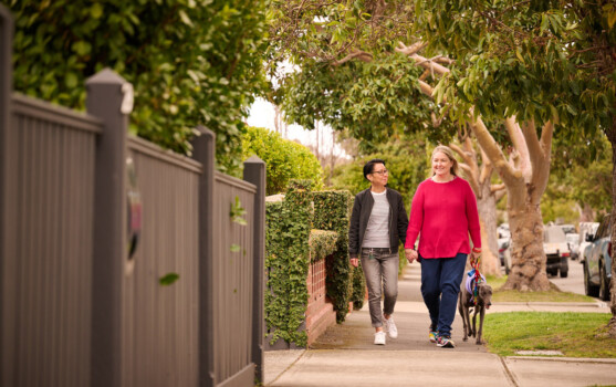 An LGBTQ+ couple walking a dog